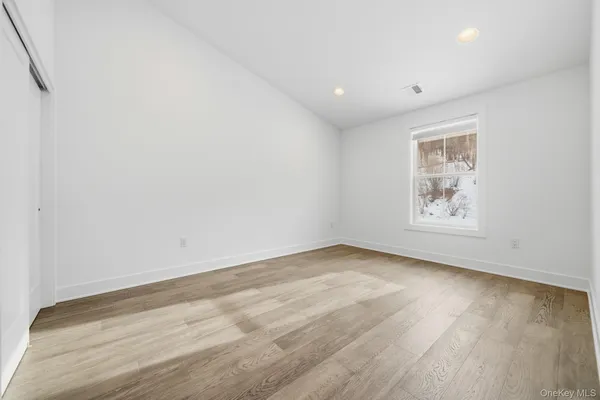 an empty room with wooden floor and window