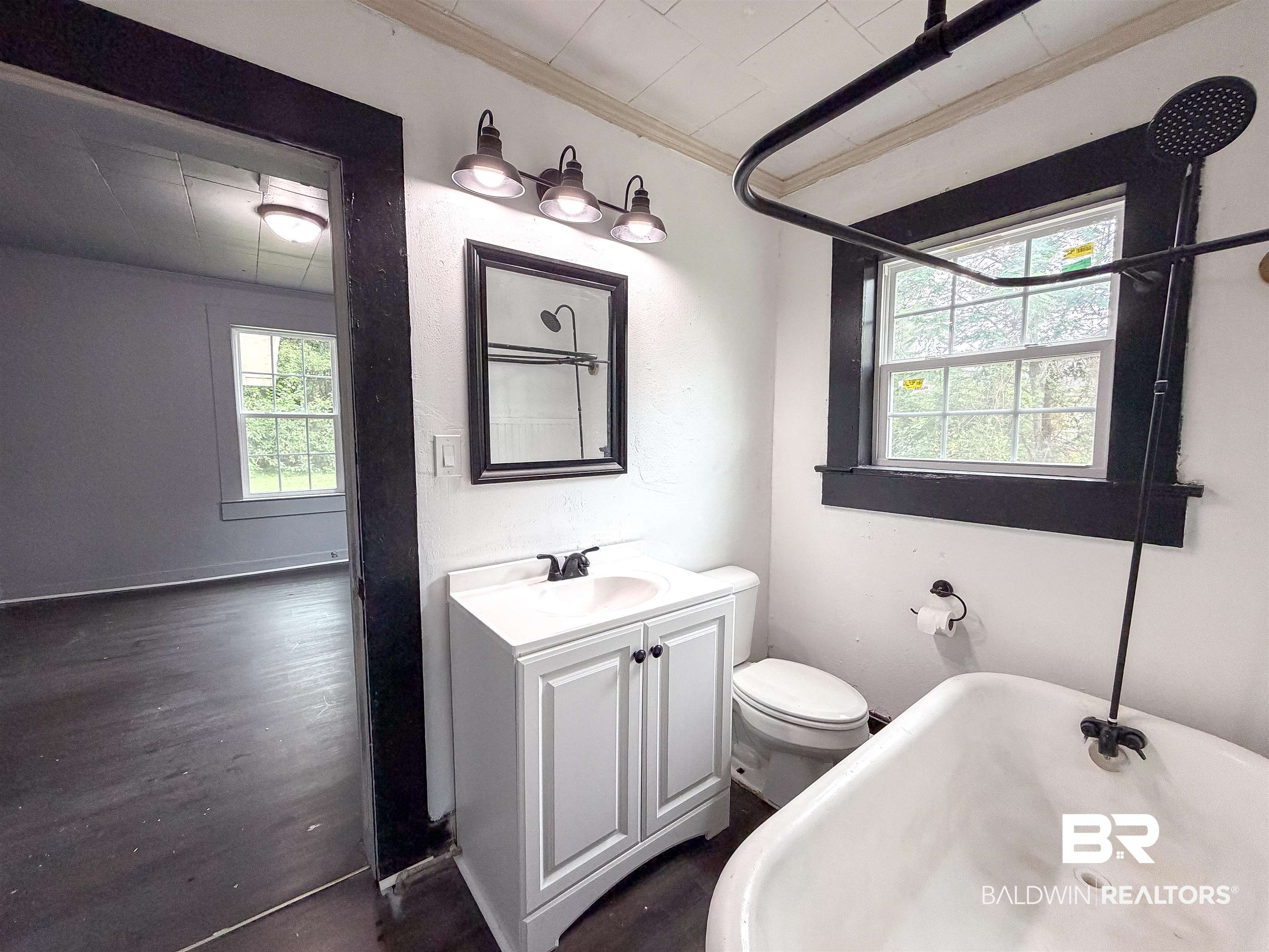 38 Flock Avenue Mobile, AL 36610 - Photo 17 of 27 Bathroom featuring a freestanding tub with a dark-finish shower fixture, white vanity with integrated sink, and an overhead vanity light