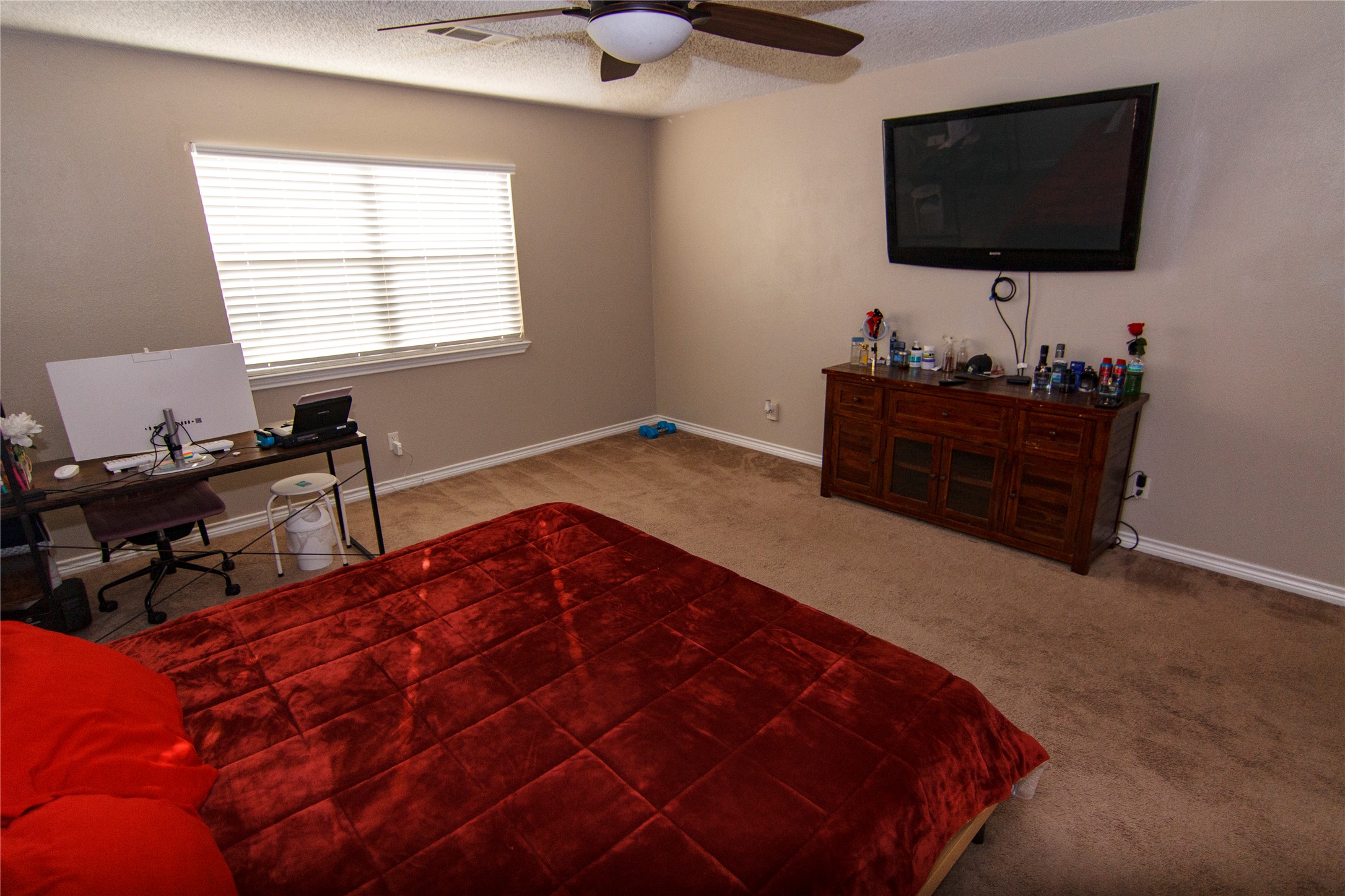 200 Keanahalululu Lane, Unit R Bastrop, TX 78602 - Photo 11 of 32 Bedroom with a desk, light carpet, a textured ceiling, and ceiling fan