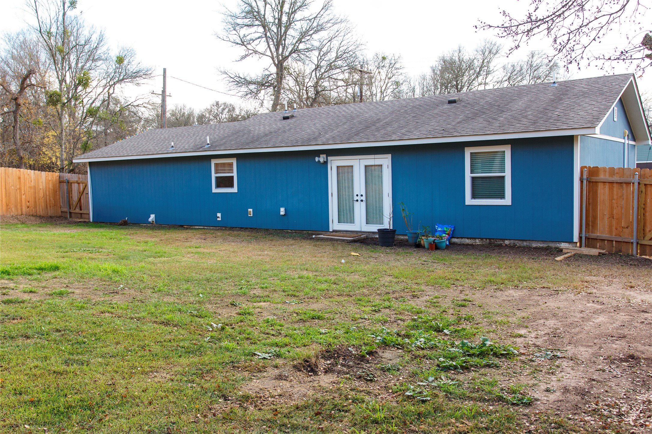 200 Keanahalululu Lane, Unit R Bastrop, TX 78602 - Photo 20 of 32 Back of property featuring a fenced backyard, french doors, and roof with shingles