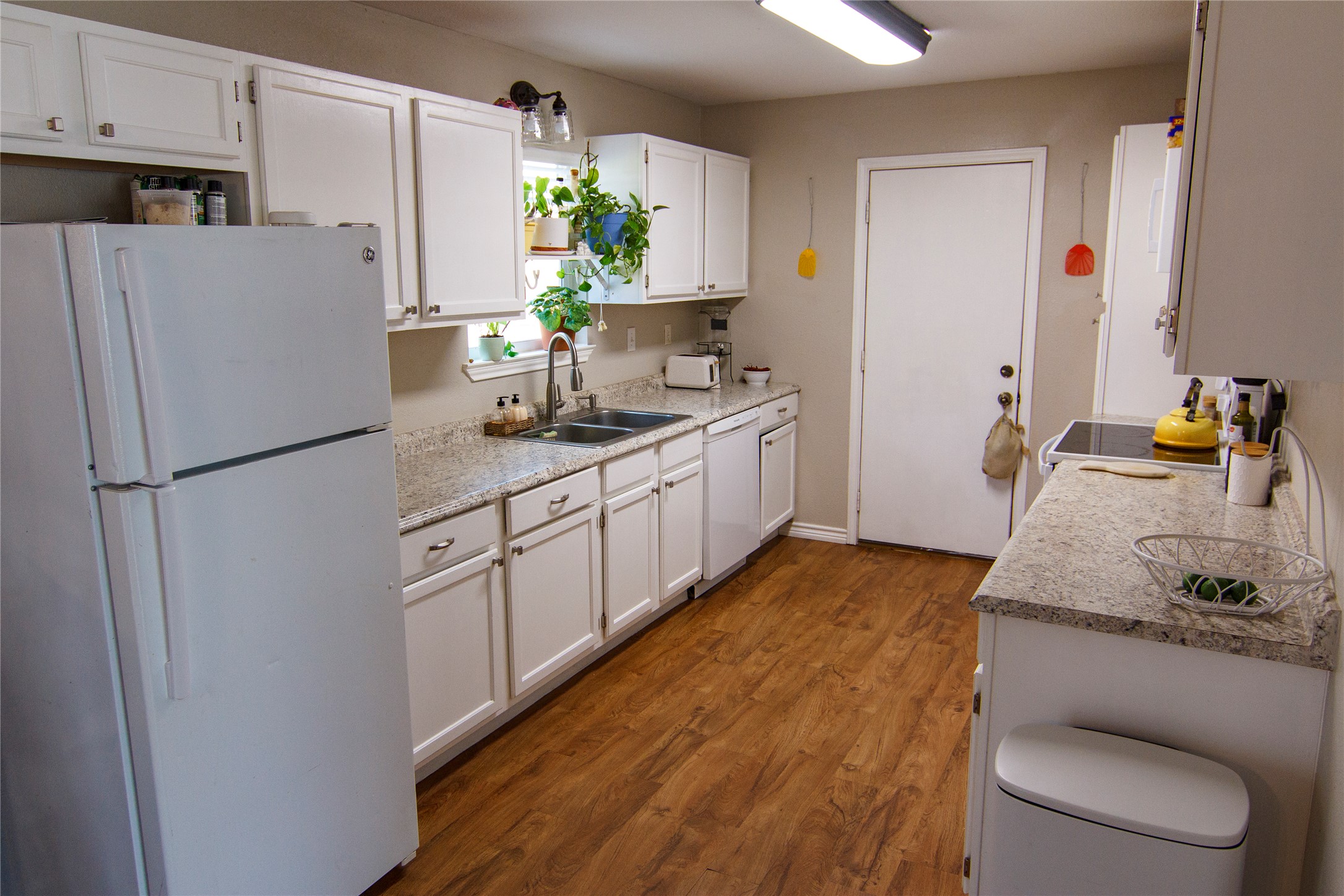 200 Keanahalululu Lane, Unit R Bastrop, TX 78602 - Photo 8 of 32 a kitchen with stainless steel appliances granite countertop a refrigerator sink and white cabinets