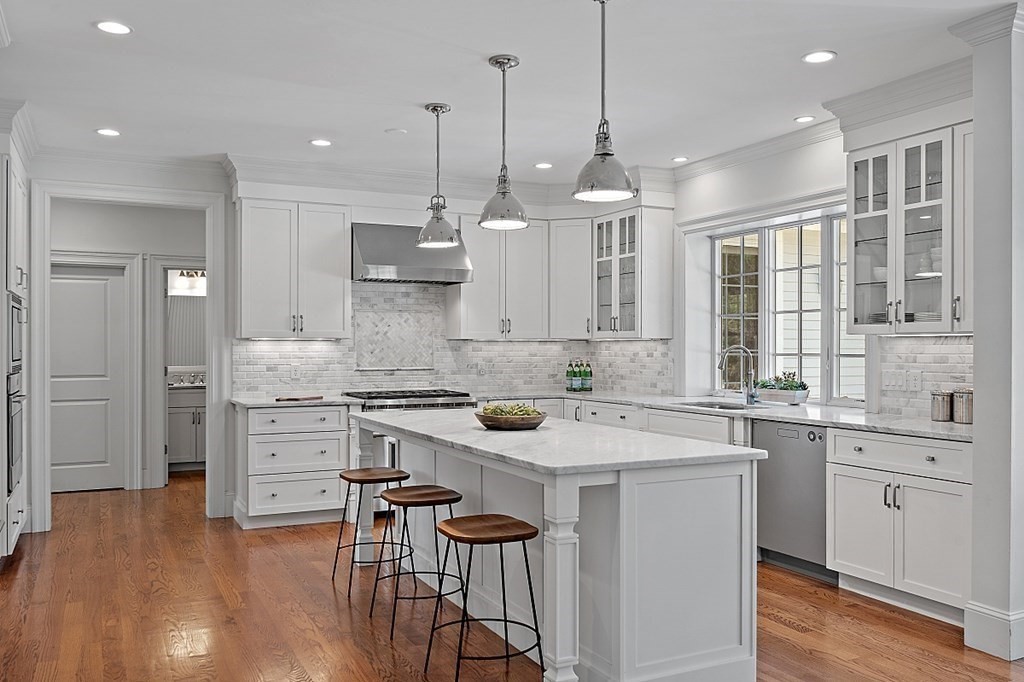 66 Oxbow Road Concord, MA 01742 - Photo 5 of 34 a kitchen with a stove a sink a center island and cabinets