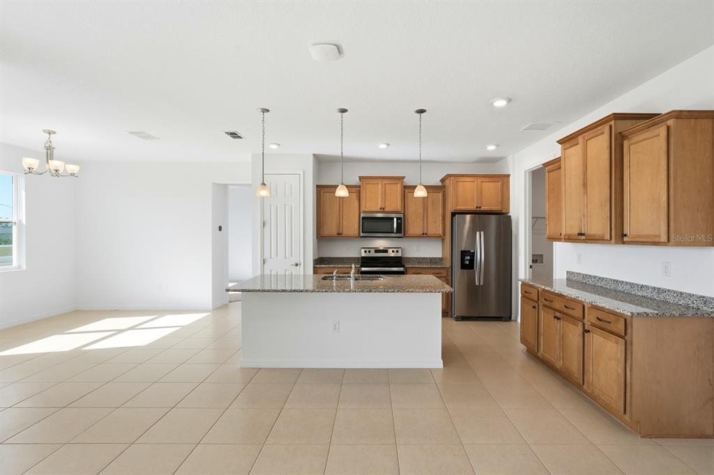 10374 Southwest 96th Street Ocala, FL 34481 - Photo 6 of 29 a large kitchen with kitchen island granite countertop a large counter top stainless steel appliances and cabinets