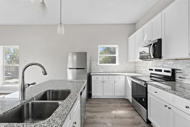 a kitchen with sink a stove and cabinets
