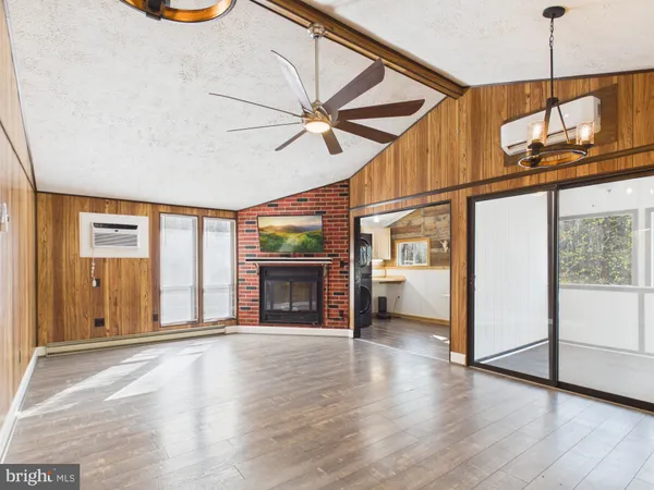 a view of an empty room with window and wooden floor