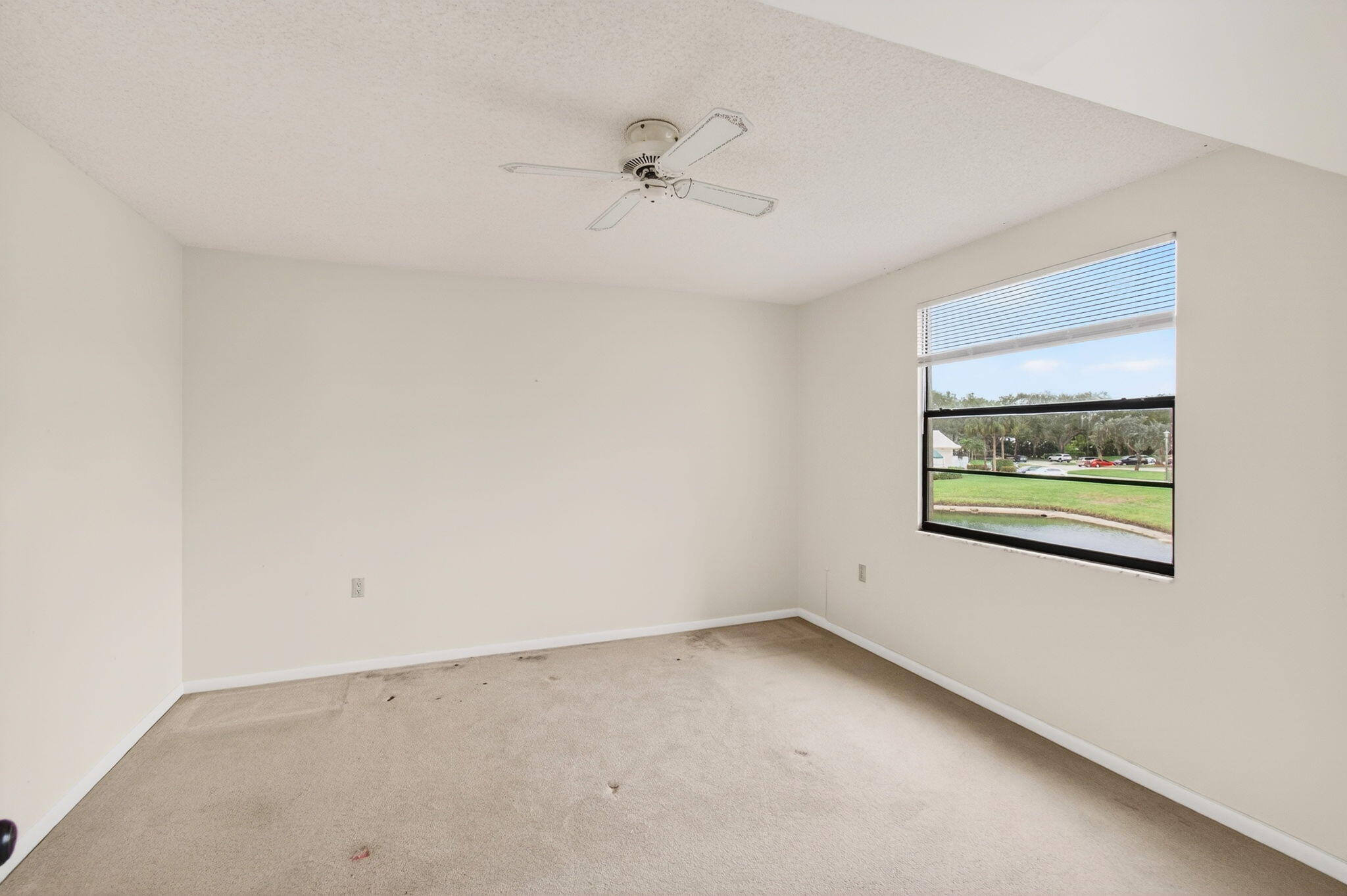 6049 Balboa Circle, Unit 205 Boca Raton, FL 33433 - Photo 19 of 27 an empty room with a window and a ceiling fan