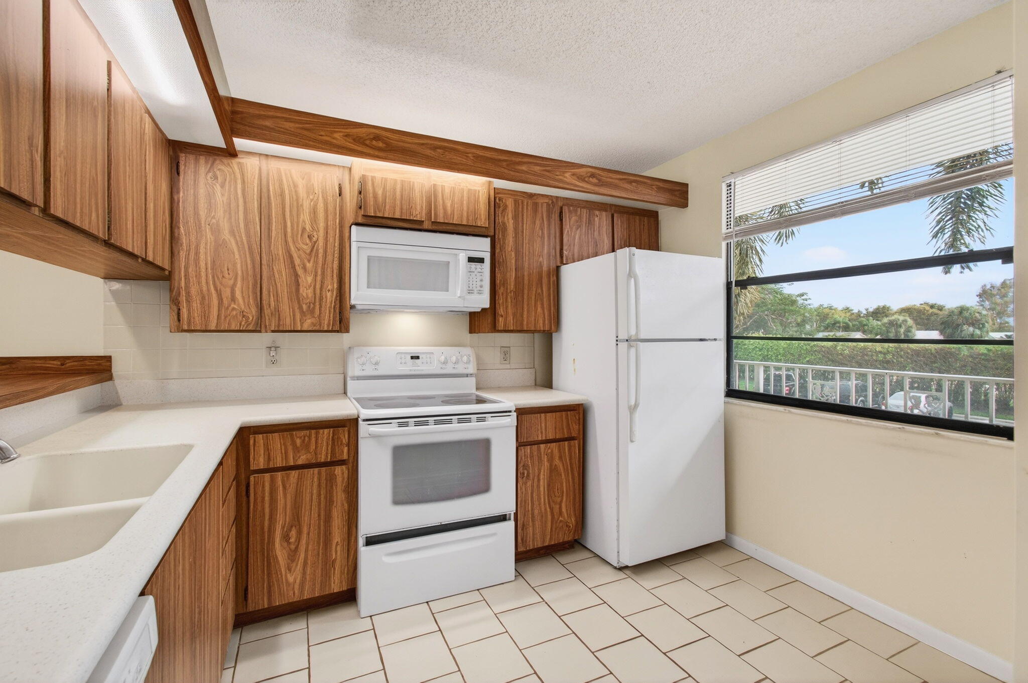 6049 Balboa Circle, Unit 205 Boca Raton, FL 33433 - Photo 6 of 27 a kitchen with stainless steel appliances granite countertop a refrigerator sink and stove
