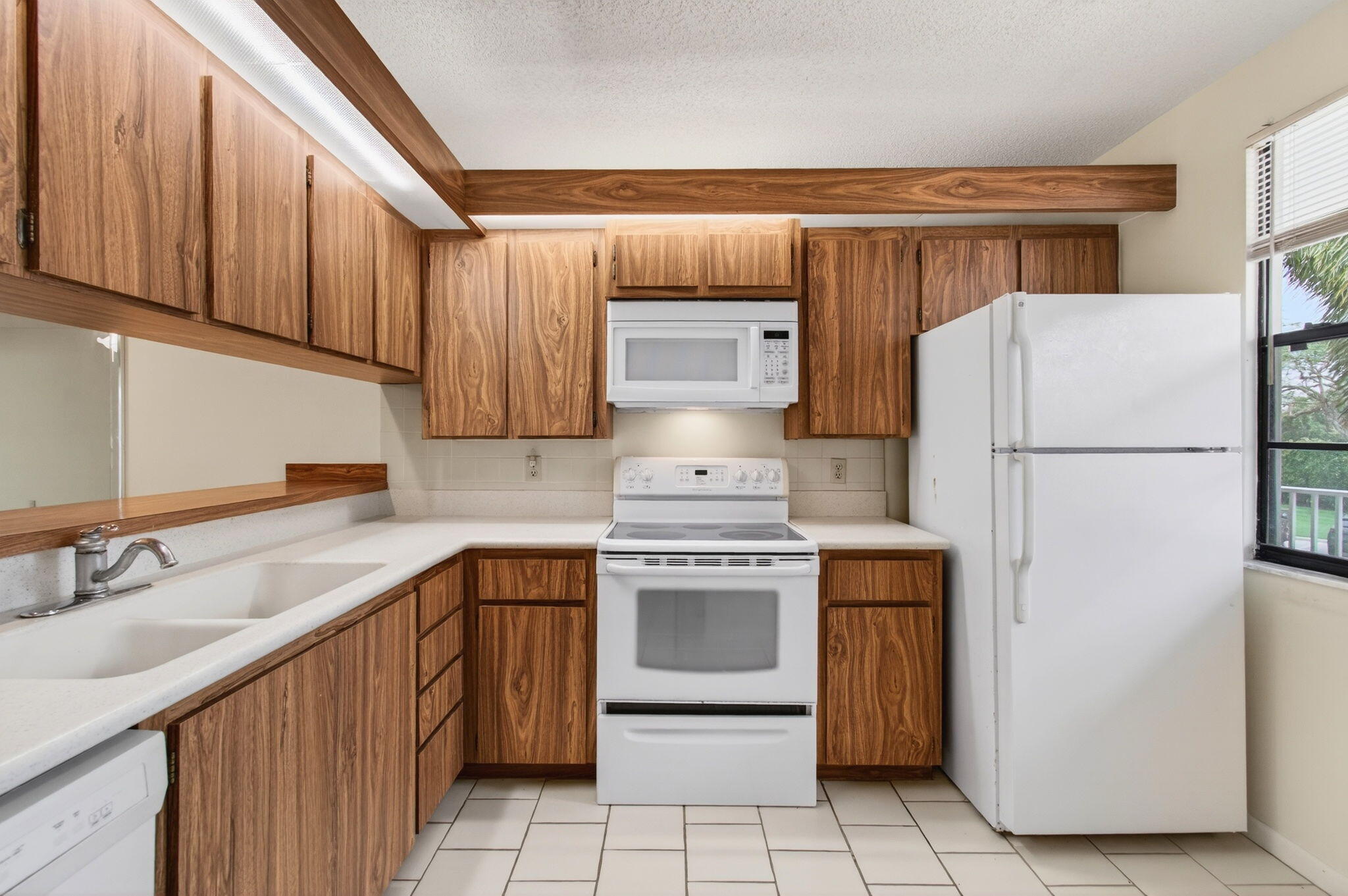 6049 Balboa Circle, Unit 205 Boca Raton, FL 33433 - Photo 7 of 27 a kitchen with a refrigerator sink and cabinets