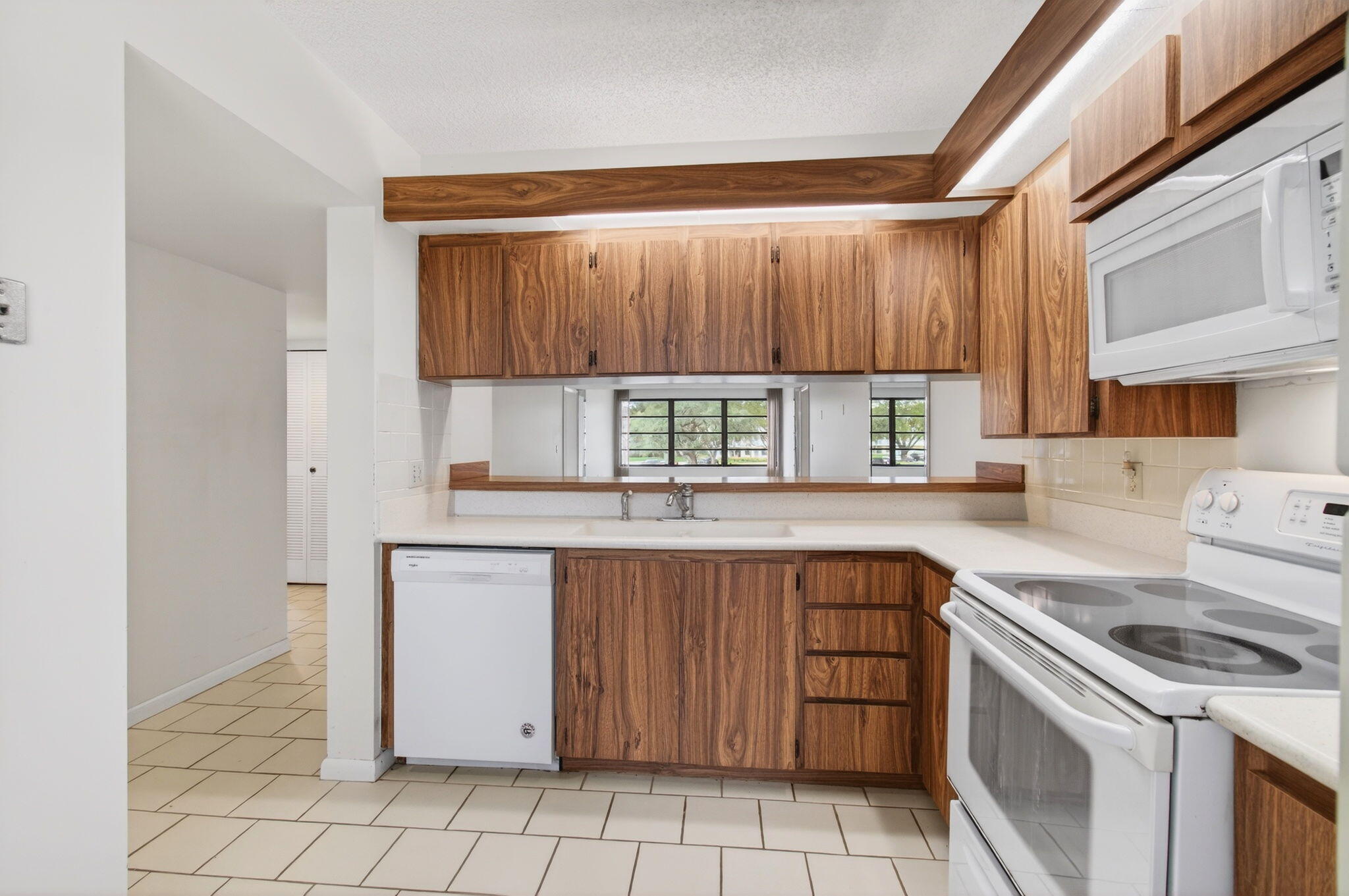 6049 Balboa Circle, Unit 205 Boca Raton, FL 33433 - Photo 9 of 27 a kitchen with a stove sink and cabinets