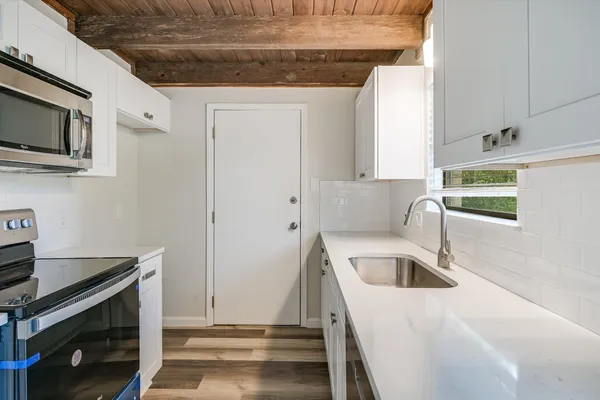 a kitchen with stainless steel appliances granite countertop a sink and a microwave
