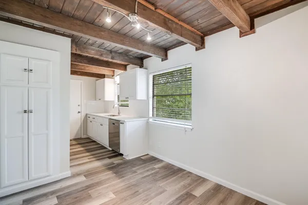 a view of a kitchen with wooden floor and electronic appliances