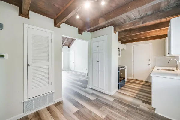 a view of a hallway with wooden floor and cabinet