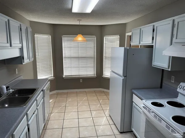 a kitchen with a refrigerator a sink and wooden cabinets