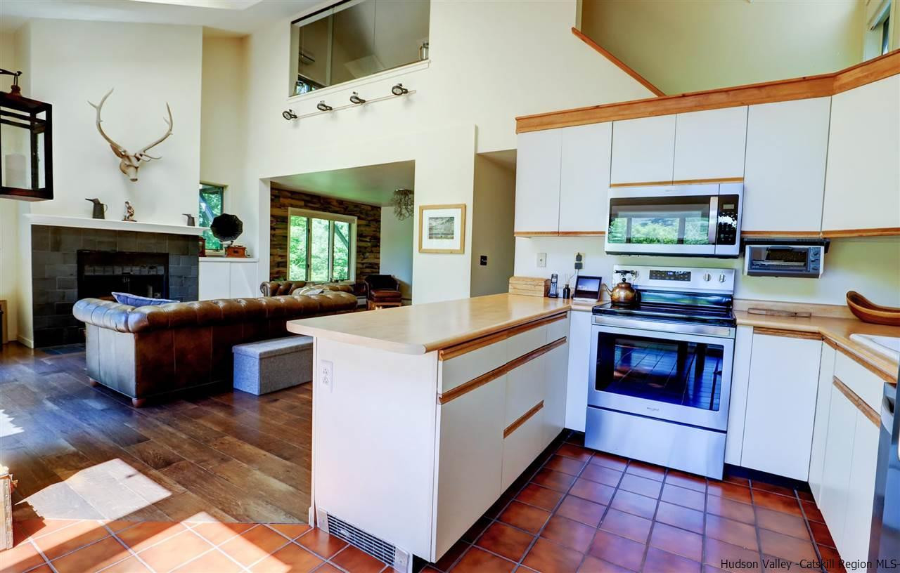 41 Mountain Road Mount Tremper, NY 12457 - Photo 12 of 33 a kitchen with stainless steel appliances kitchen island granite countertop a stove and a microwave