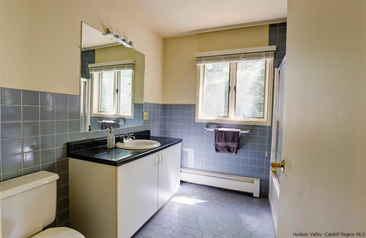41 Mountain Road Mount Tremper, NY 12457 - Photo 15 of 33 a bathroom with a granite countertop sink toilet and mirror