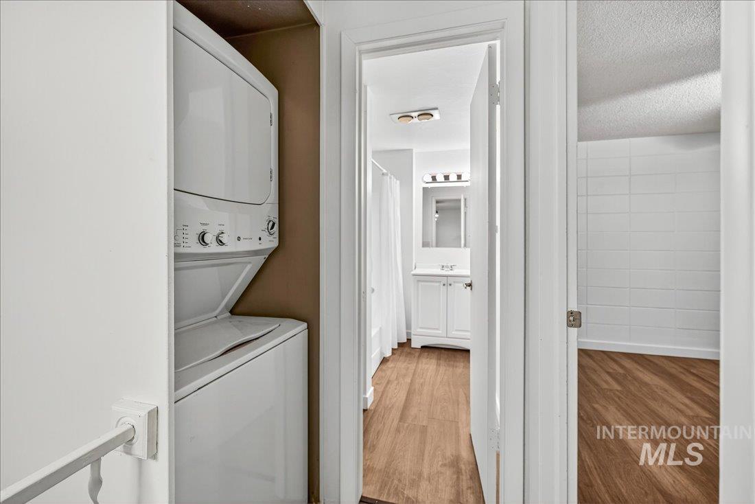 824 South Curtis Road Boise, ID 83705 - Photo 19 of 19 Washroom with light wood-style flooring, stacked washer / dryer, and a textured ceiling