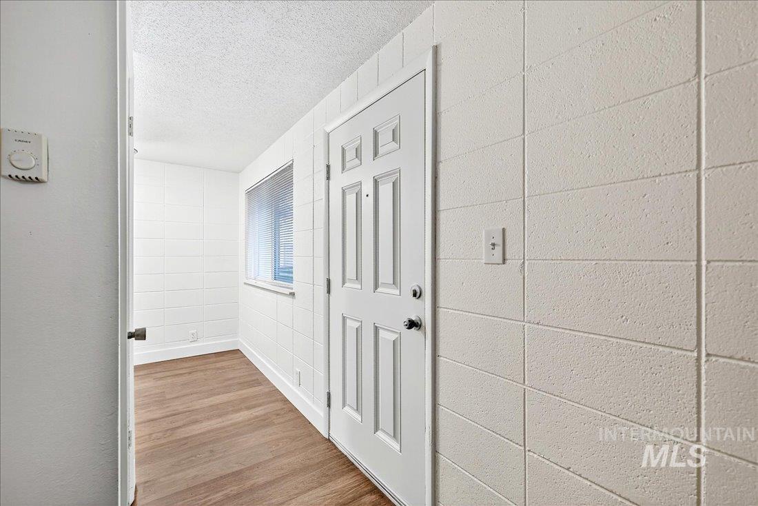 824 South Curtis Road Boise, ID 83705 - Photo 6 of 19 Hall with light wood-style flooring and a textured ceiling
