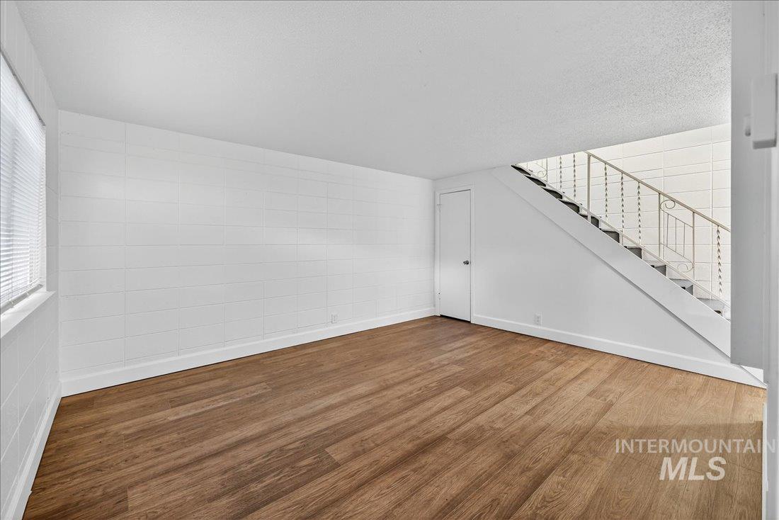 824 South Curtis Road Boise, ID 83705 - Photo 7 of 19 Unfurnished living room featuring wood finished floors and stairs