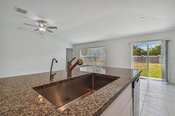 a kitchen with a granite countertop sink a stove and a granite counter top