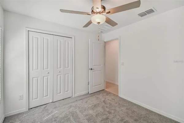 an empty room with a ceiling fan and a window
