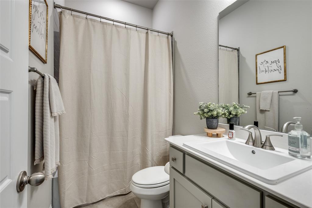 1113 Stone Bridge Pass Gunter, TX 75058 - Photo 18 of 32 a bathroom with a granite countertop sink toilet and a mirror