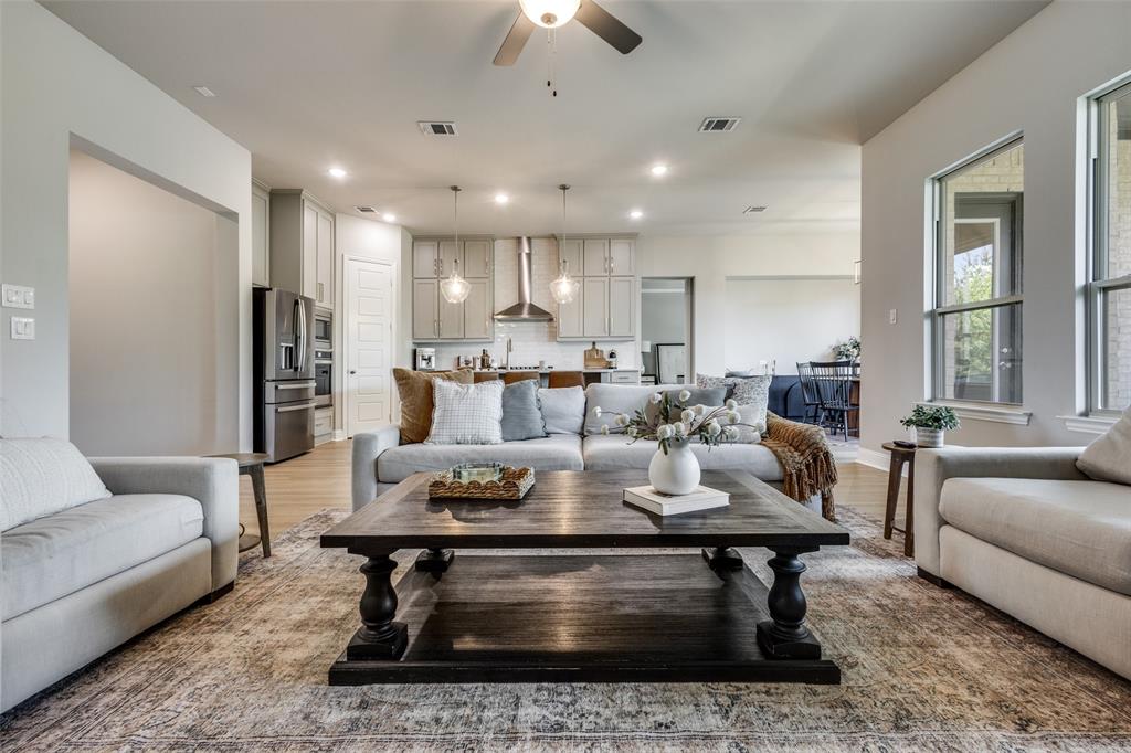 1113 Stone Bridge Pass Gunter, TX 75058 - Photo 5 of 32 a living room with furniture a rug and a chandelier