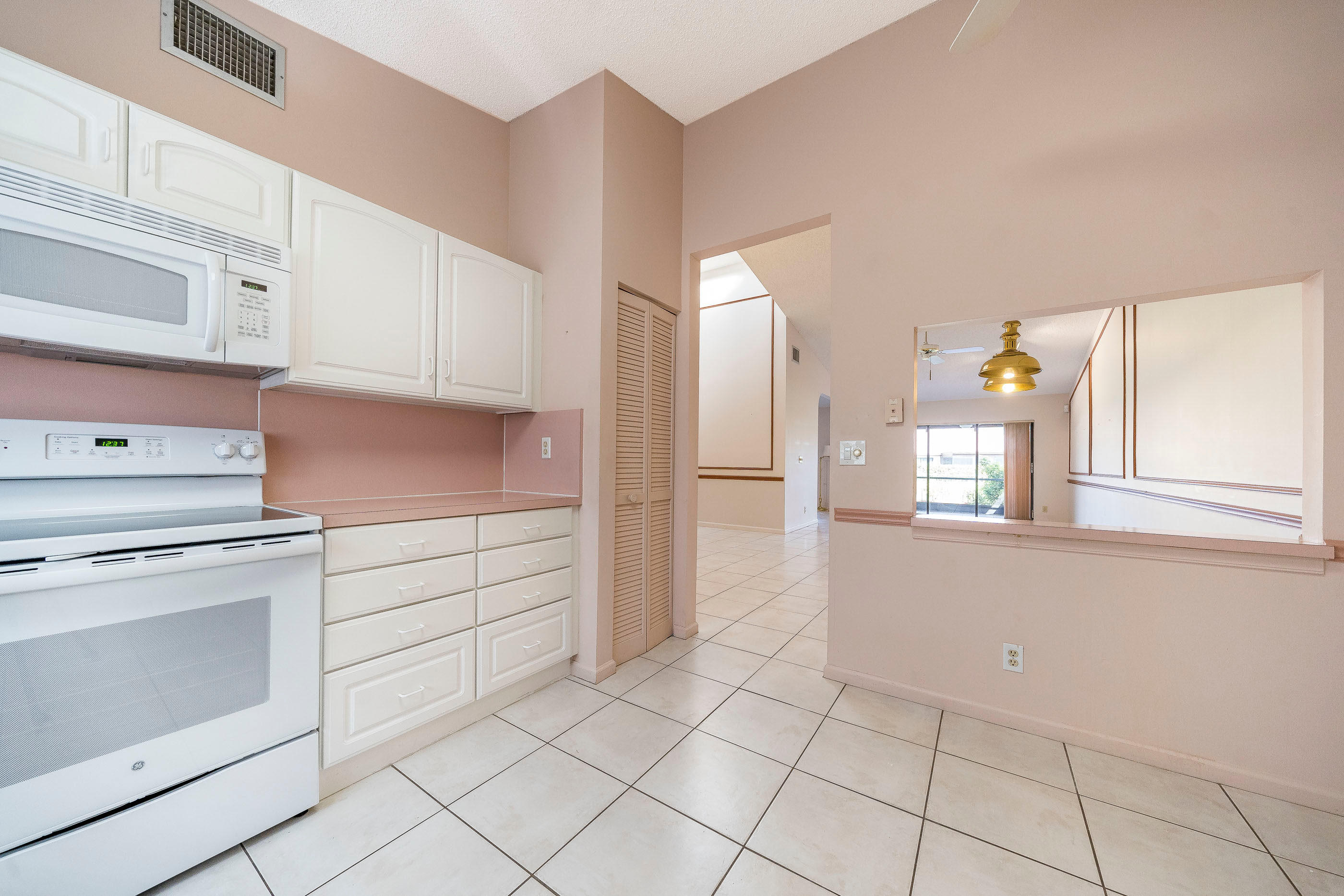 7723 Solimar Circle Boca Raton, FL 33433 - Photo 10 of 40 a kitchen with granite countertop white cabinets and appliances