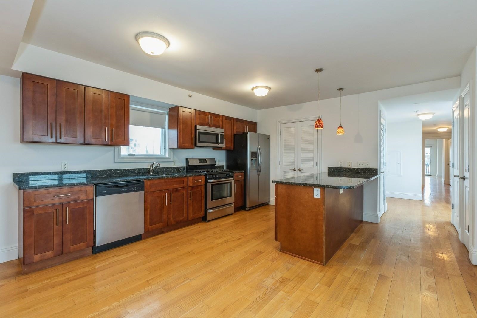 125 43rd Street, Unit 405 Union City, NJ 07087 - Photo 11 of 20 a kitchen with stainless steel appliances granite countertop a stove a sink and a refrigerator