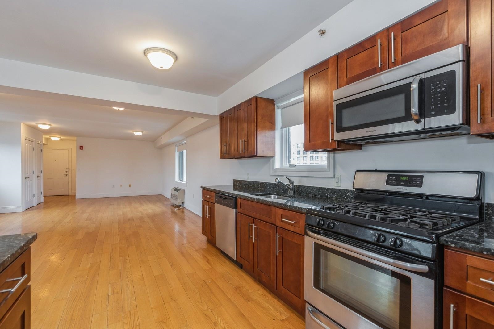 125 43rd Street, Unit 405 Union City, NJ 07087 - Photo 12 of 20 a kitchen with stainless steel appliances granite countertop a stove and a microwave