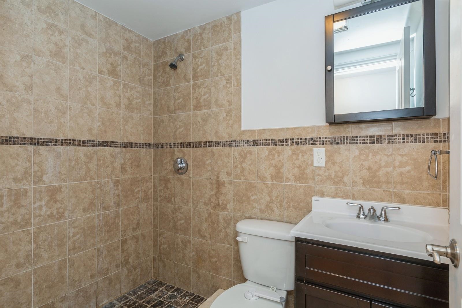 125 43rd Street, Unit 405 Union City, NJ 07087 - Photo 17 of 20 a bathroom with a granite countertop sink a toilet and shower