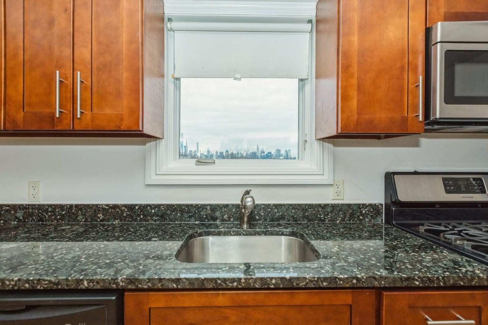 125 43rd Street, Unit 405 Union City, NJ 07087 - Photo 10 of 20 a kitchen with granite countertop a sink and a window