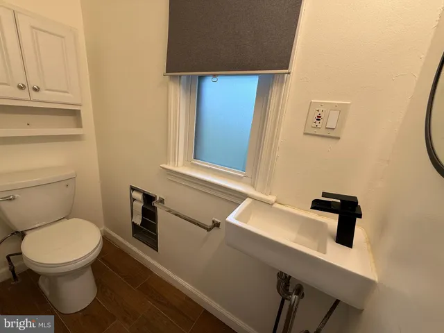 a bathroom with a toilet a sink and mirror
