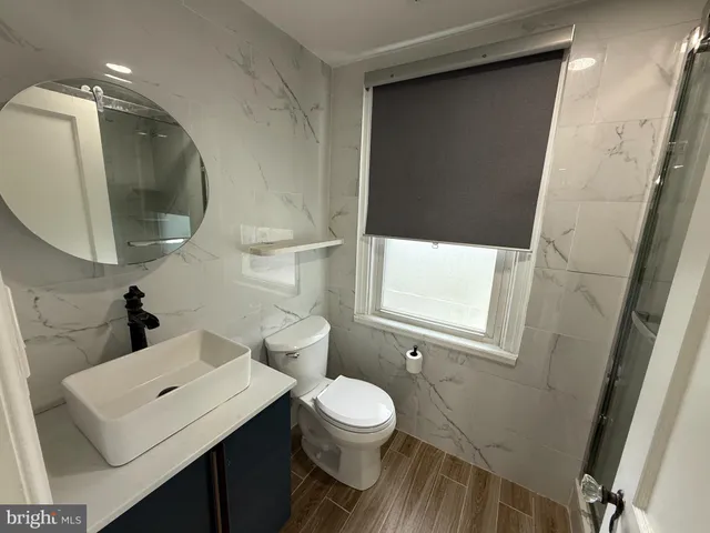 a bathroom with a toilet a sink and mirror