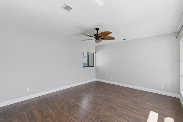 a view of a room with wooden floor and a ceiling fan