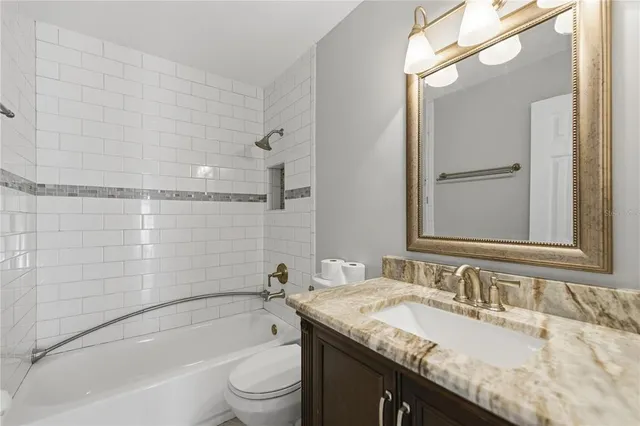 a bathroom with a granite countertop sink toilet and shower
