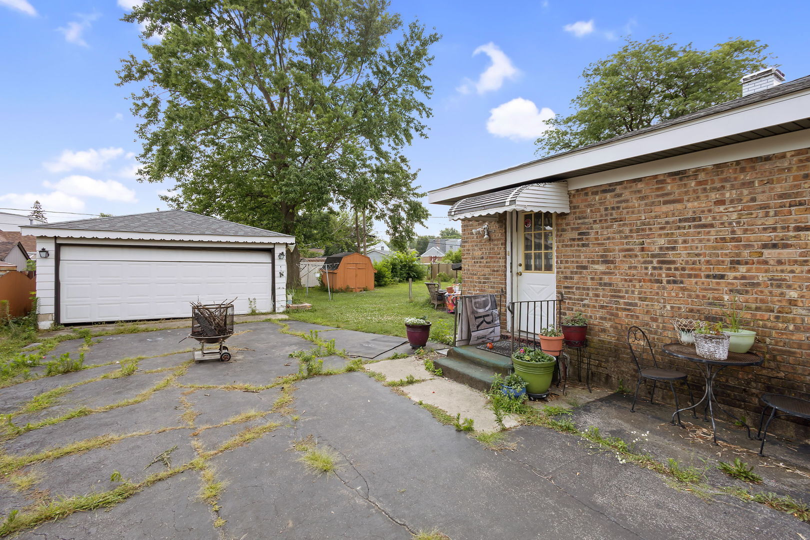 10741 Mason Avenue Chicago Ridge, IL 60415 - Photo 19 of 23 a view of a patio with table and chairs with wooden fence and plants