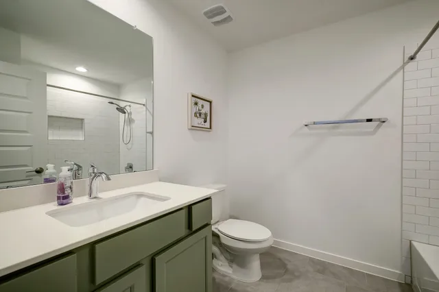 a bathroom with a sink vanity mirror and toilet