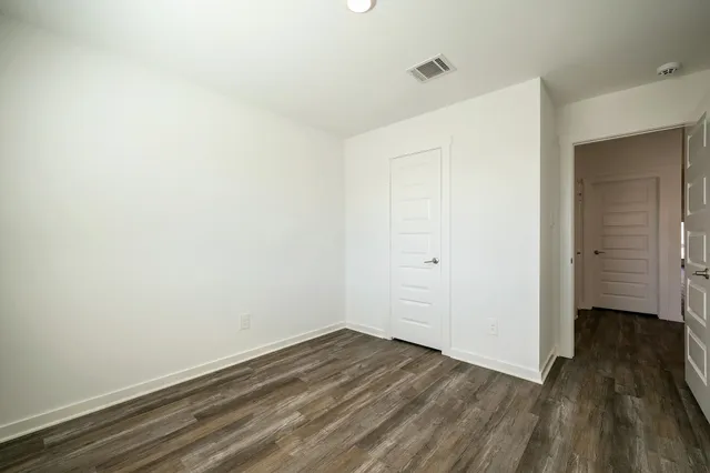 a view of a room with wooden floor and a ceiling fan