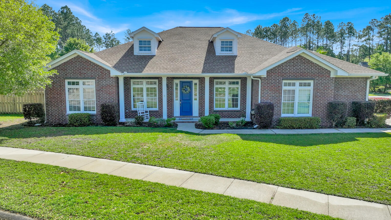 a front view of a house with a yard and trees