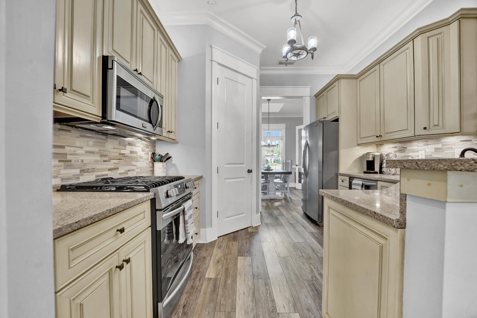 738 Symphony Way Freeport, FL 32439 - Photo 15 of 69 a kitchen with stainless steel appliances granite countertop a stove top oven a sink dishwasher and a refrigerator with wooden floor