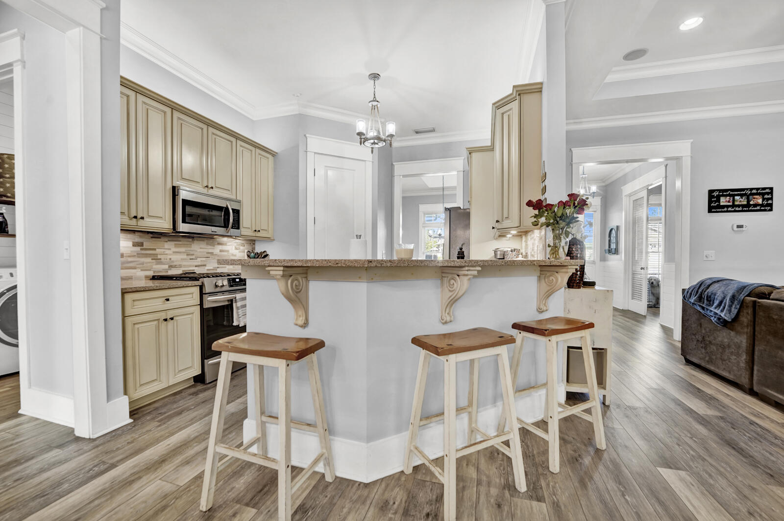 738 Symphony Way Freeport, FL 32439 - Photo 16 of 69 a kitchen with stainless steel appliances kitchen island granite countertop a table chairs cabinets and wooden floor
