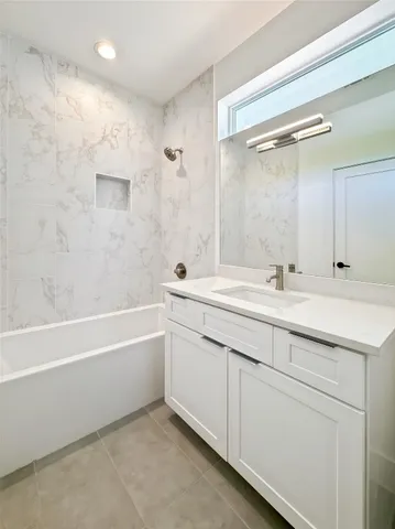 a bathroom with a double vanity sink mirror and a bathtub