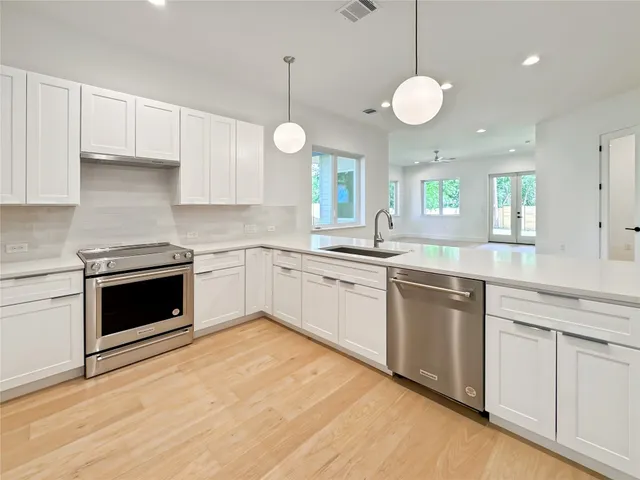 a kitchen with granite countertop white cabinets and white appliances