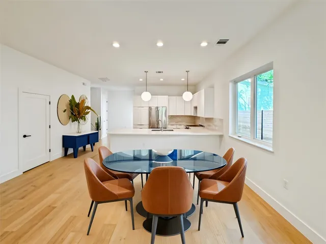 a dining room filled chandelier and wooden floor