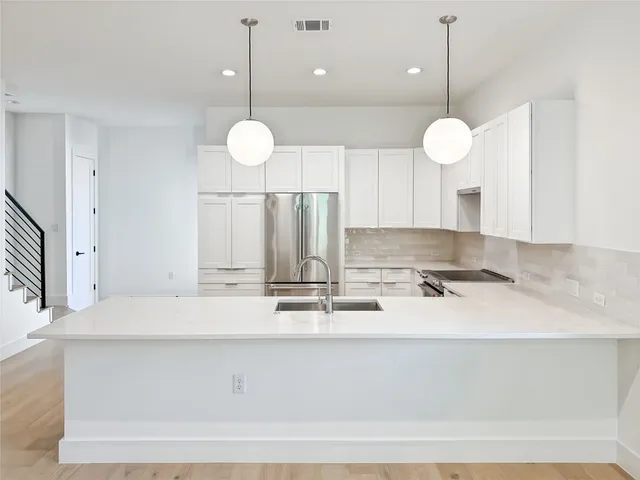a large kitchen with lots of counter space and wooden floor