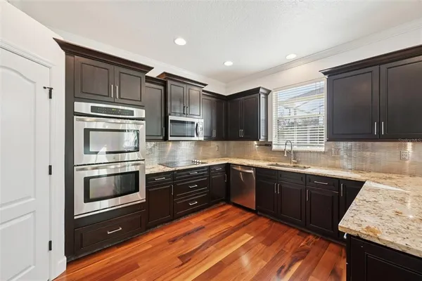 a kitchen with stainless steel appliances granite countertop a stove microwave and sink