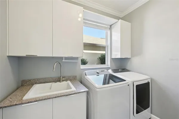 a utility room with sink dryer and washer