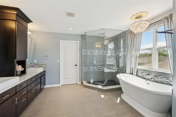 a spacious bathroom with a tub sink a mirror and a shower