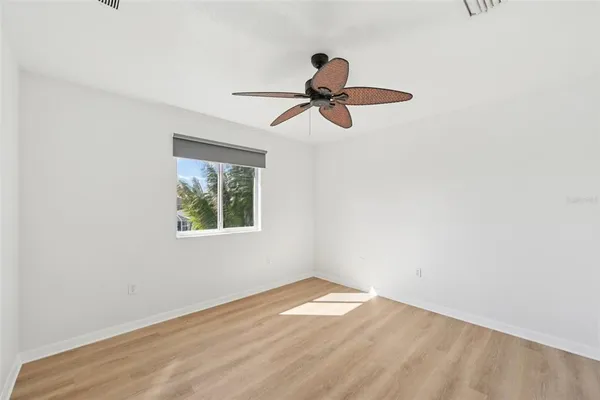 an empty room with a window and a ceiling fan