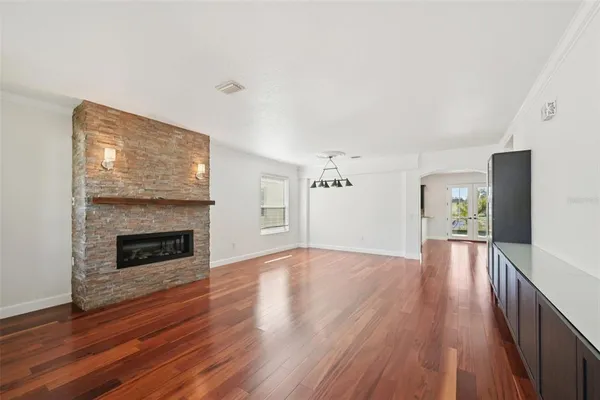 a view of empty room with wooden floor and fireplace